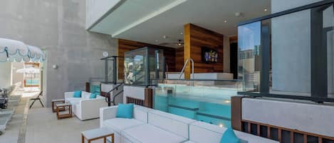 Un espacio lounge moderno al aire libre con piscina, asientos y vistas a la ciudad.
