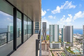 A high-rise building with large windows, a balcony, and a view of the cityscape and sea. - Skyline Miami & Resort Amenities (Miami)