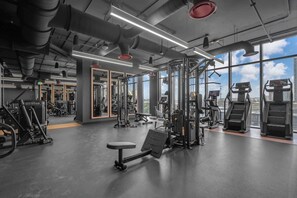A gym with various exercise equipment, large windows, and a view of the city. - Skyline Miami & Resort Amenities (Miami)