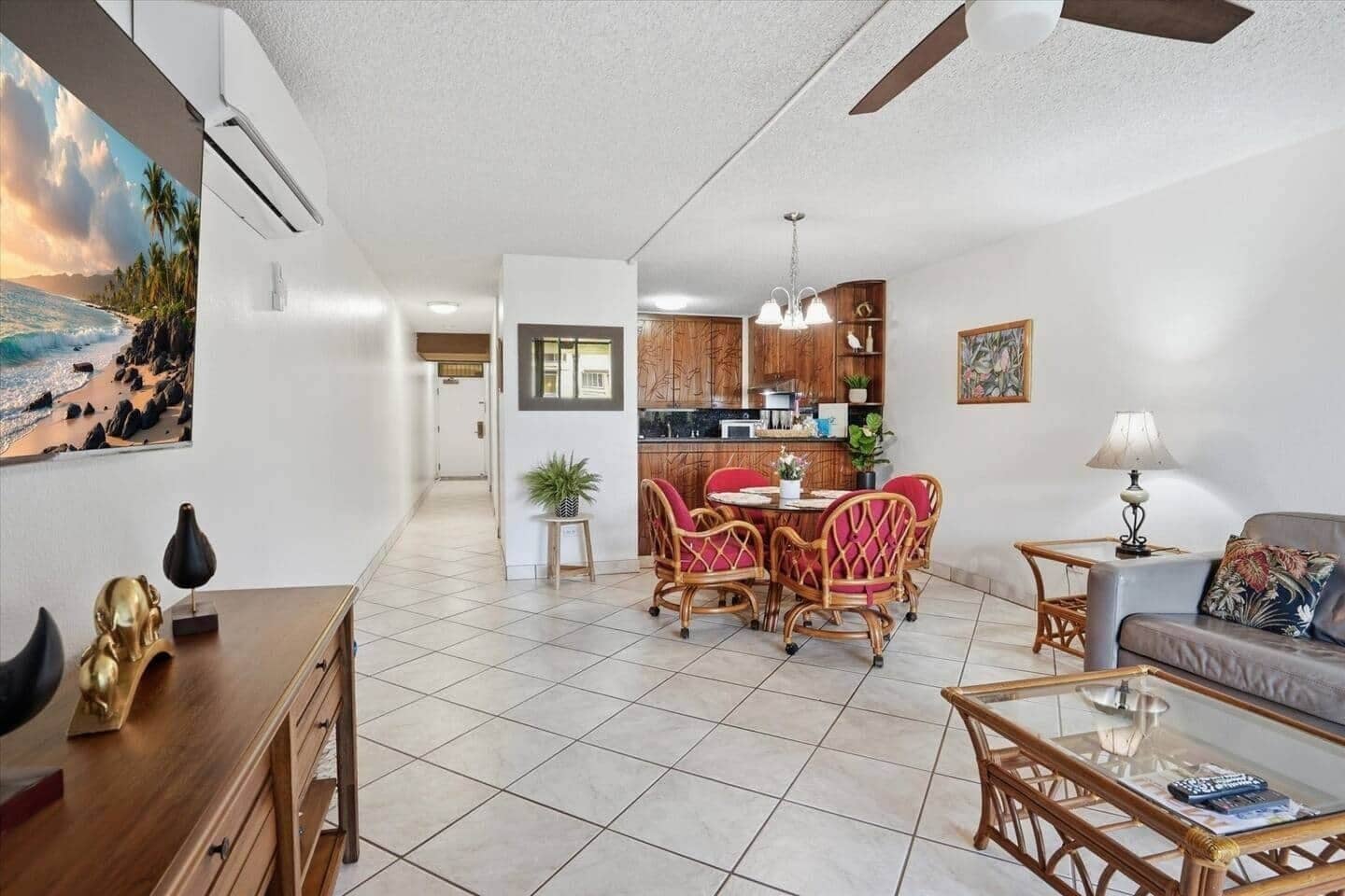 A spacious living area with a dining table, red chairs, a sofa, and a coffee table.
