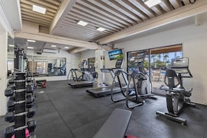 Ein Fitnessstudio mit Laufbändern, Crosstrainern und Gewichten.