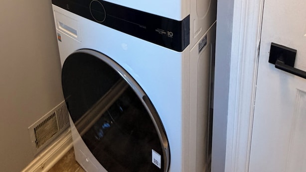Una lavadora y secadora apiladas, con un panel de control y un pomo.