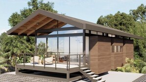 A modern building with a glass facade, wooden exterior, and a balcony with seating. - Casa la Onda "Ultra" Suite (Provincia de Puntarenas)