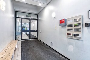 A hallway with a fire safety plan sign, a control panel, and a bench. - Industrial-Style Cityscape 1 Bedroom Loft (Edmonton)