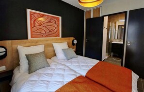 A hotel room with a bed, a headboard, a wall art piece, a wardrobe, and a bathroom visible through an open door. - Wifi, 100m from ski slopes, swimming pool, sauna, hammam, balcony, tv, ski locker, 37m², Auron (Auron)
