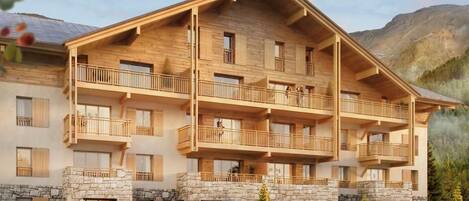 Un edificio de madera de varios pisos con balcones, base de piedra y montañas al fondo.