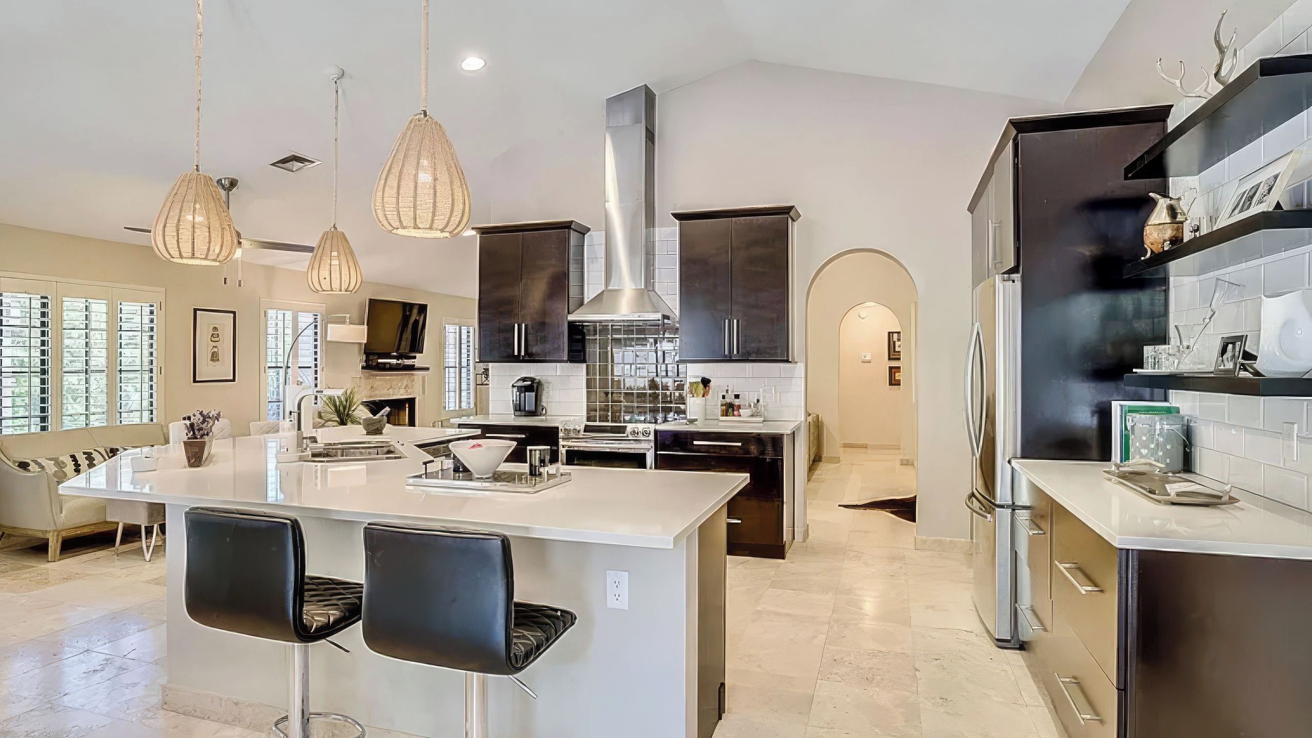 A modern kitchen with a central island, pendant lighting, and a built-in stove.