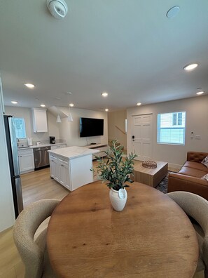 A modern kitchen with white cabinets, a built-in dishwasher, and a flat-screen TV mounted on the wall. - Spacious 4-bedroom townhome in delightful Los Angeles with AC (Los Angeles)