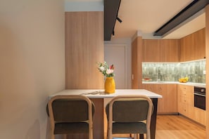 A modern kitchen with wooden cabinets, a white countertop, and a yellow vase with flowers. - 3 Comfy Houses by HostWise (Porto)