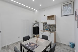 A compact kitchen with a microwave, gas stove, and a small cabinet.