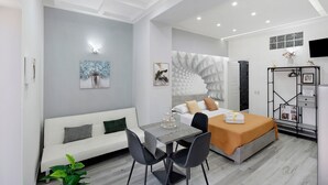 Une chambre d’hôtel moderne équipée d’un lit, d’un coin salon, d’un bureau et d’une armoire.