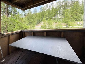 A wooden deck with a table and benches, overlooking a forested area. - 150m from ski slopes, 6th floor, balcony, 57m², Les Orres (Les Orres)