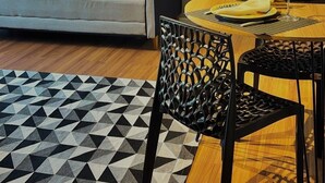 A modern living room with a sofa, dining table, chairs, a geometric rug, and a colorful painting on the wall. - Zoe  (Foz do Iguaçu)