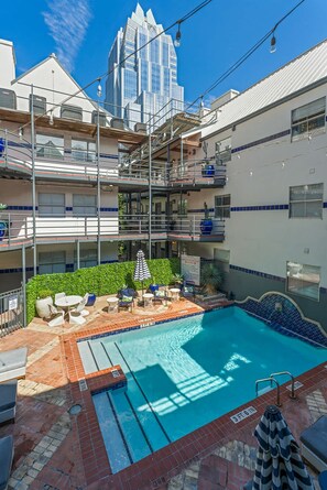 A rooftop swimming pool with a view of a tall building in the background. - Spacious Austin Retreat 3BR Pool Views (Austin)