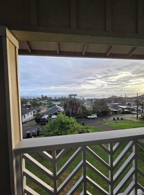 Blick vom Balkon mit Geländer auf ein Wohngebiet mit Häusern und Grünflächen.