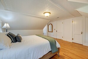 Ein Schlafzimmer mit Bett, Lampe, Spiegel und Tür.
