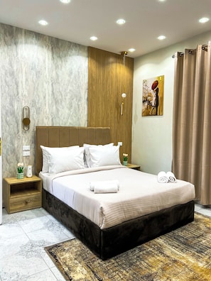 Ein modernes Schlafzimmer mit einem großen Bett, einem Holz-Kopfteil und einer Wand mit Marmor-Muster.