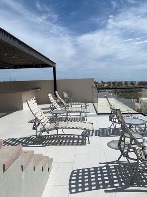 A rooftop terrace with outdoor seating, a pergola, and a city view. - 2-bedroom Seaview  penthouse apartment in peaceful Cabo San Lucas with AC (Cabo San Lucas)