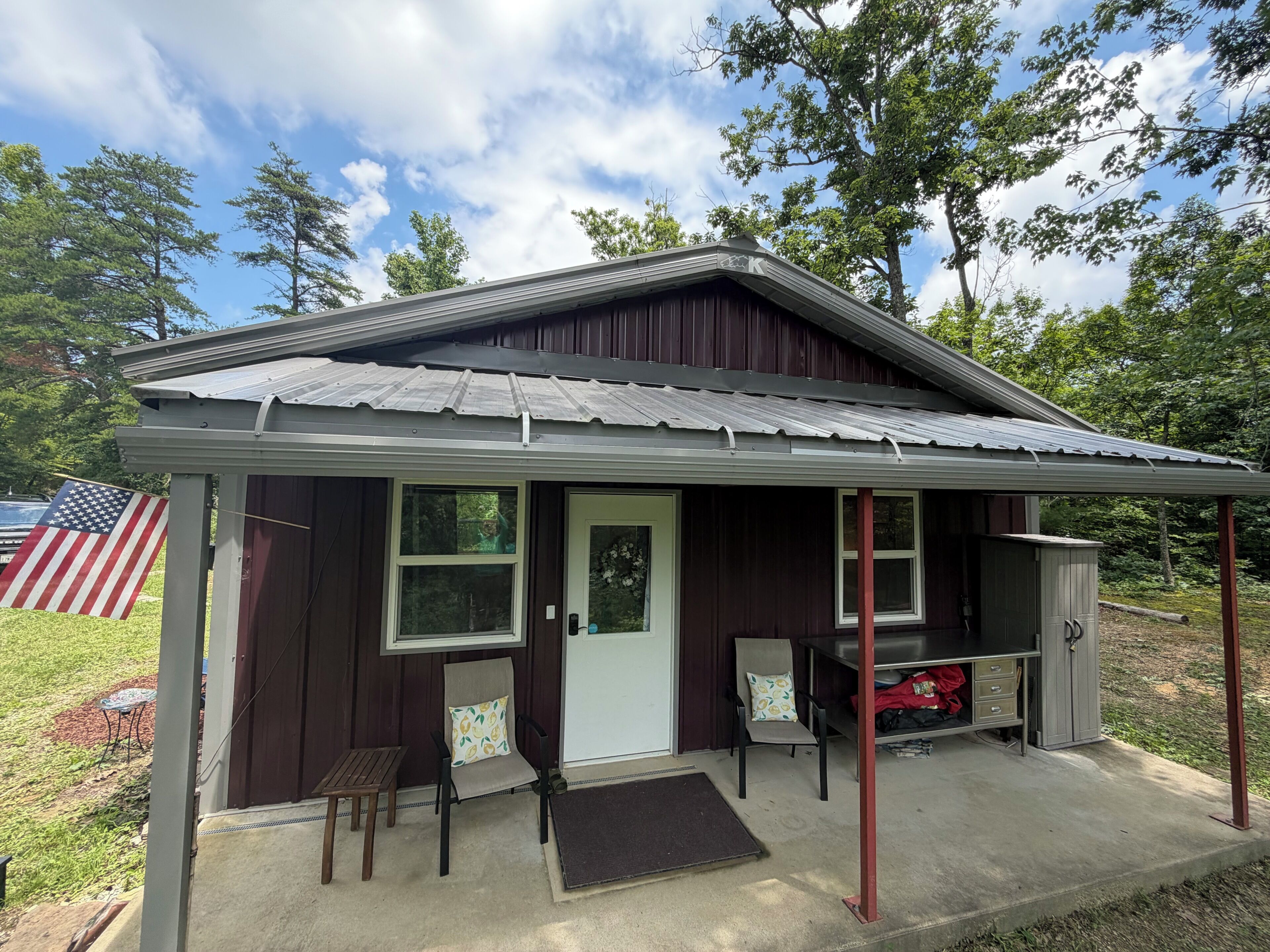 A small, single-story building with a porch, a door, and two windows.