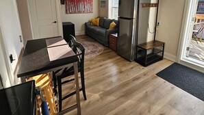 Cocina compacta con comedor, refrigerador y sofá.