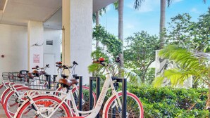 A row of bicycles parked outside a building with a sign indicating a 'TOY-AND-PLAY ZONE.' - 28th Floor Studio w Marina View & Pool (Hallandale Beach)