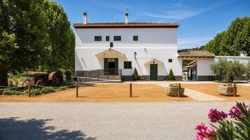 Un bâtiment blanc avec un toit en tuiles, une porte verte et un petit porche.