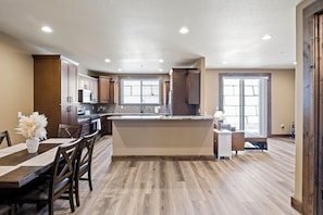 A spacious kitchen with wooden cabinets, a central island, and a dining area with a table and chairs. - Beautiful 2-bedroom apartment in Sutherlin - Minutes from I-5! (Sutherlin)