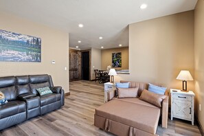 A modern living room with a sofa, a bed, a dining area, and a kitchen in the background. - Beautiful 2-bedroom apartment in Sutherlin - Minutes from I-5! (Sutherlin)