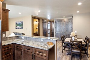 A kitchen with granite countertops, wooden cabinets, and a dining area with a table and chairs. - Beautiful 2-bedroom apartment in Sutherlin - Minutes from I-5! (Sutherlin)