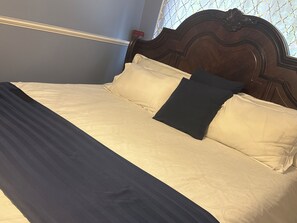 A bed with a headboard, pillows, and a bedspread. - Spacious 6-bedroom house in quaint Graham with AC (Graham)