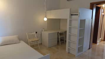 A bedroom with a bed, a desk, a chair, and a wardrobe.