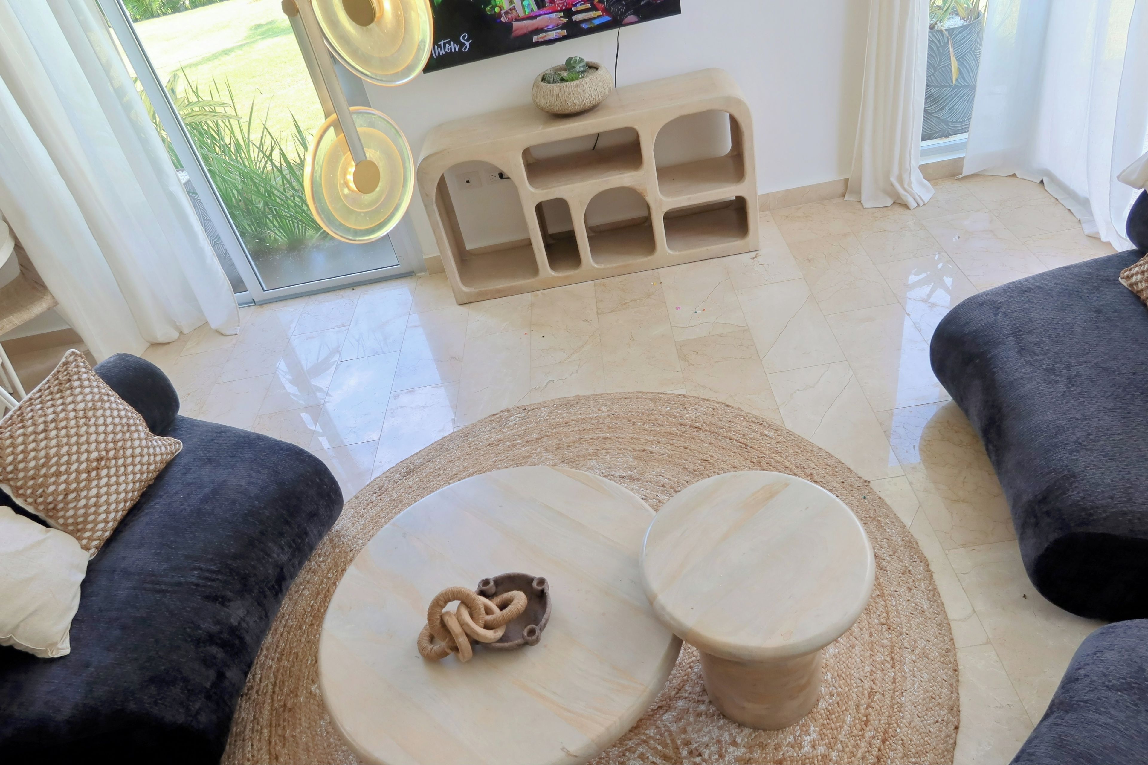 Un salon moderne avec un canapé, une table basse et un téléviseur.