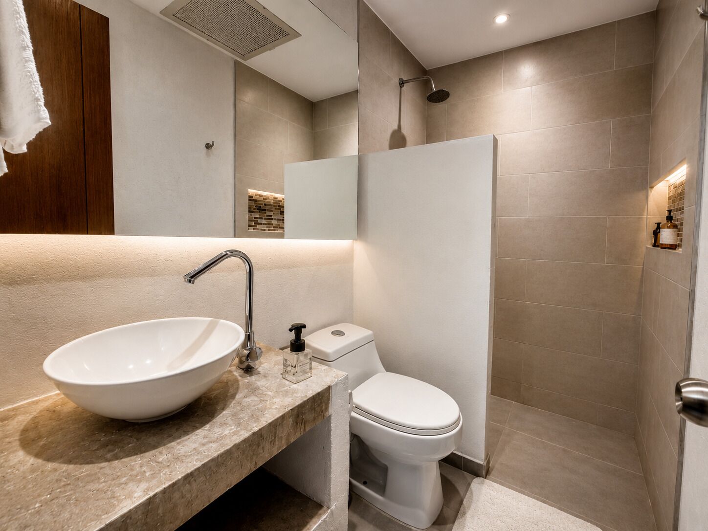 Ein modernes Badezimmer mit Waschbecken, Toilette und Duschbereich.