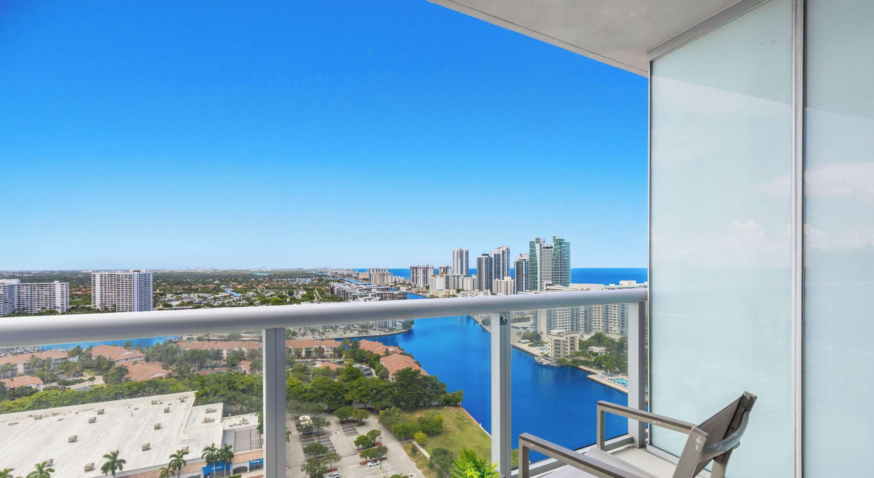 Un balcón con vistas a un horizonte urbano y una masa de agua.