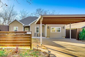 A residential property with a covered patio, a fenced yard, and a driveway. - Sauna, Hot Tub & Backyard Fun in OKC (Oklahoma City)