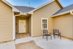 A house with a front door, a window, and two chairs outside. - Sauna, Hot Tub & Backyard Fun in OKC (Oklahoma City)