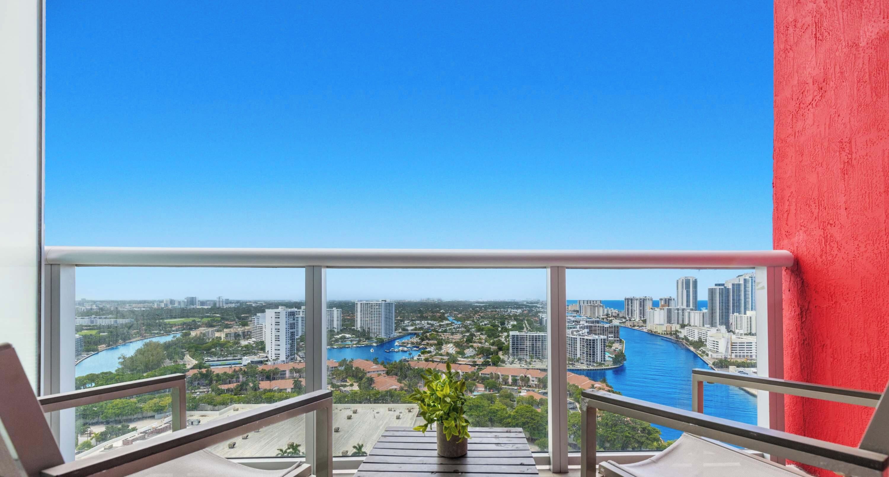 A balcony with a view of a cityscape and a river.