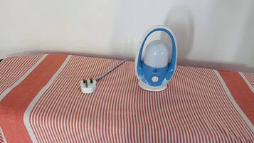 A blue and white electric kettle on a striped tablecloth.