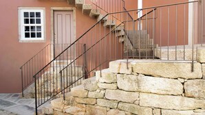 Ein pinkfarbenes Gebäude mit einer Steintreppe und einem Metallgeländer.
