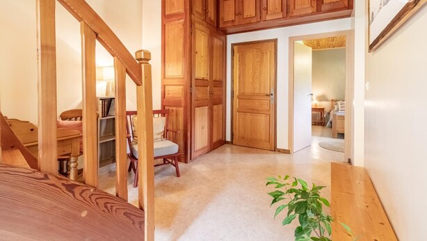 A wooden staircase leading to a bedroom with a bed, a chair, and a plant. - Androsace - VAL CENIS (VAL CENIS)