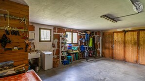A room with a concrete floor, wooden cabinets, a bicycle, and a window with a view. - Androsace - VAL CENIS (VAL CENIS)