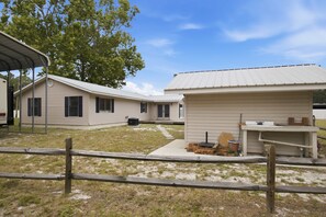 Une rangée de chalets de plain-pied, dotés d’un espace extérieur couvert et d’une clôture en bois.
