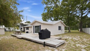 A mobile home with a patio, a barbecue grill, and a covered outdoor seating area. - New- Eastpoint- Next to RV park- Pet Friendly (Eastpoint)
