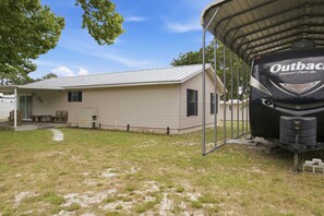 A mobile home with a covered outdoor area, a small porch, and a recreational vehicle parked nearby. - New- Eastpoint- Next to RV park- Pet Friendly (Eastpoint)