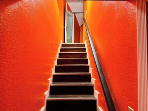 A staircase with wooden steps and a metal handrail, leading to a door at the top. - Spacious Jonesboro Retreat | Near Downtown | Fully Stocked Kitchen | Smart TVs (Jonesboro)