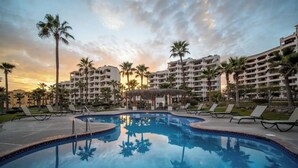 A resort pool with palm trees, lounge chairs, and a sunset sky. - A302 Casa Blanca Golf Villas 3-bedroom condo with AC in Puerto Peñasco (Puerto Peñasco)