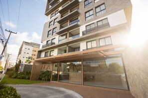 Un immeuble à plusieurs étages doté de balcons, d’une entrée en verre et d’une enseigne portant l’inscription « NOA ».