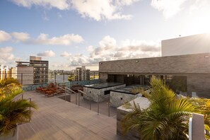 Une terrasse sur le toit, avec des sièges en plein air et une vue sur le paysage urbain.