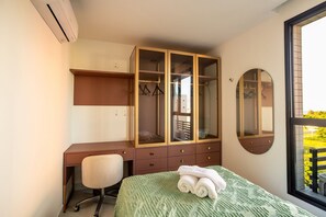 A bedroom with a bed, a desk, a chair, a wardrobe, and a window. - NOA Residence Club in Ponta de Campina With Rooftop and Full Leisure by Carpediem (Cabedelo)