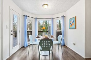 Un comedor con una mesa redonda, sillas y vistas al exterior.